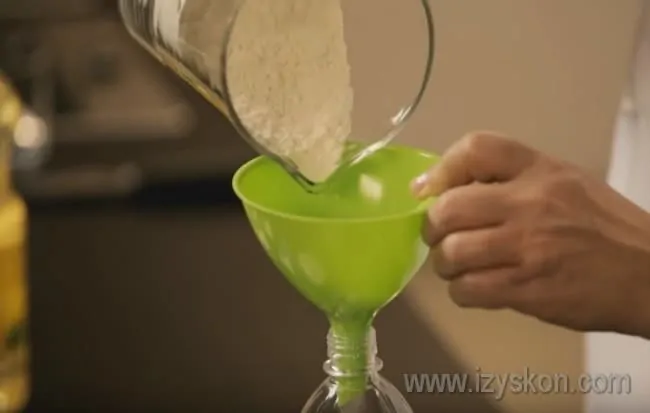 Через воронку насыпаем в бутылку муку.